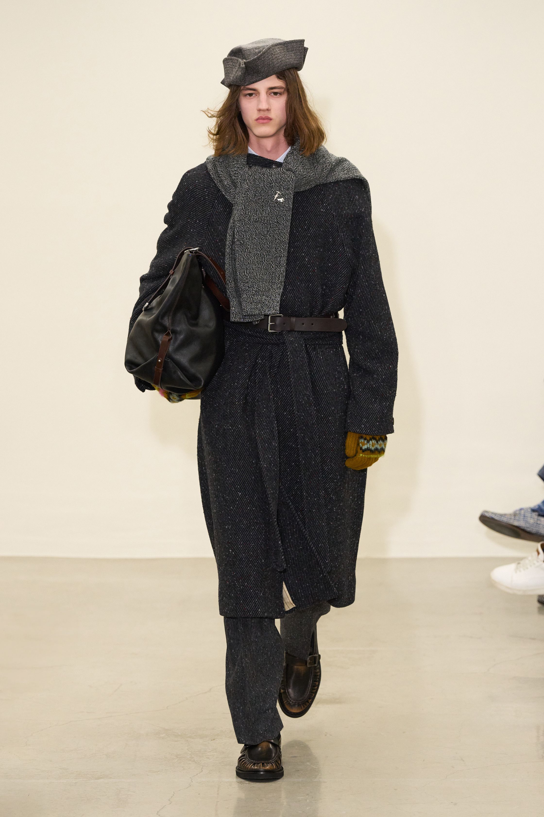 Paul Smith 2026秋冬回归品牌最具识别度的“英式日常诗意”。系列以传统剪裁为骨架，却通过色彩点缀、围巾叠搭与比例微调，赋予男装更松弛的情绪温度。西装不再严肃，风衣与大衣在肩线与长度上释放空间，搭配针织与衬衫形成轻度混搭。整体传递的是一种文化型男性的穿衣态度——不追逐潮流，却始终保持幽默感与个人风格-顽石频道趋势研究